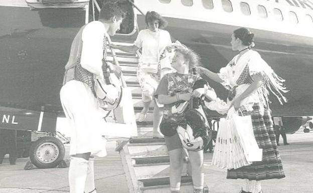 Dos jóvenes ataviados de huertanos reciben a los pasajeros de un avión británico en mayo de 1995.