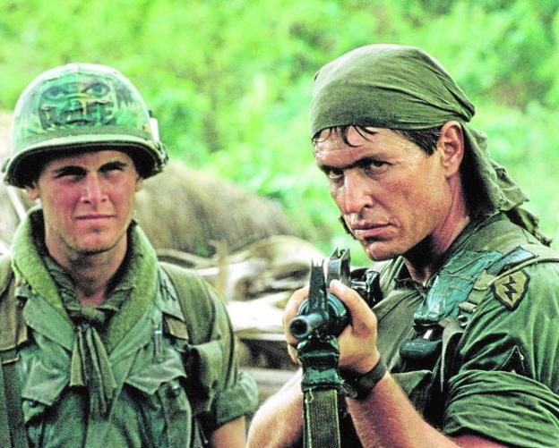 Tom Berenger, apuntando con el arma, en una escena de la película 'Platoon'./