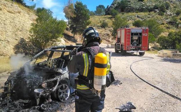 Bomberos, durante su intervención en el incendio del vehículo.