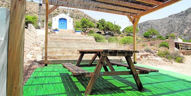 Zona de mesas y bancos para el pícnic en El Portús, delante de la ermita en la que se ha instalado iluminación. /Pablo Sánchez / AGM
