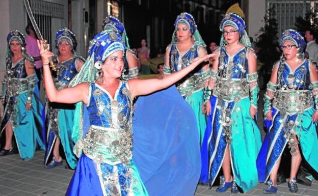 Un grupo de bailarinas, lujosamente ataviadas, recorriendo las calles de la localidad en la noche del sábado.