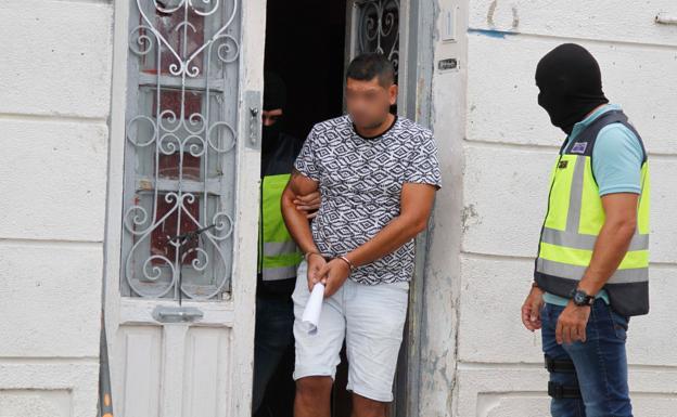 Uno de los detenidos abandona la vivienda, en el barrio de San Félix.