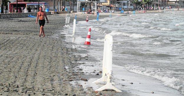 Un veraneante pasea junto a las vallas que impedían el baño en la playa del Espejo.