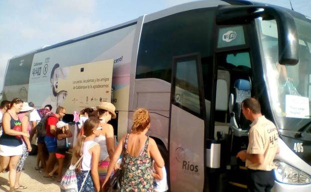 Veraneantes acceden al autobús para ir a las playas del parque regional de Calblanque.