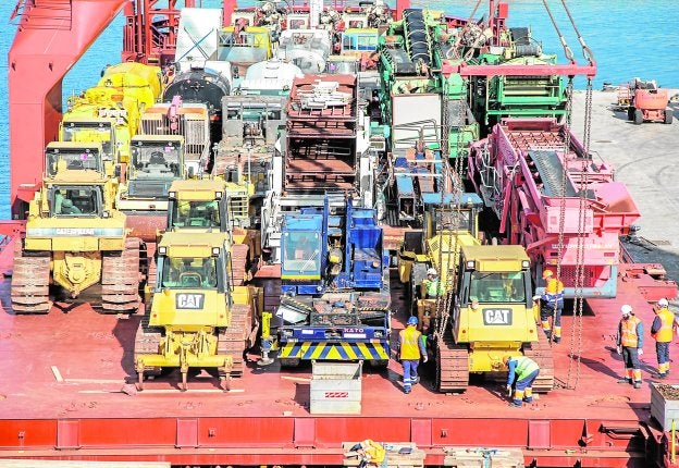 Un grupo de trabajadores del puerto preparan las máquinas para descargarlas de uno de los barcos llegados a los muelles de Cartagena desde Argelia.