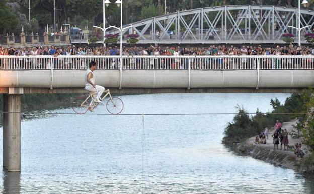 Momento en que el volatinero avanza sobre un cable de 90 metros de longitud con miles de personas expectantes alrededor del Puente Viejo.