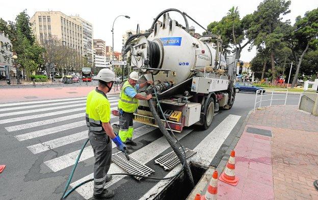 Trabajadores de Hidrogea limpian la red de saneamiento en la Plaza de España.