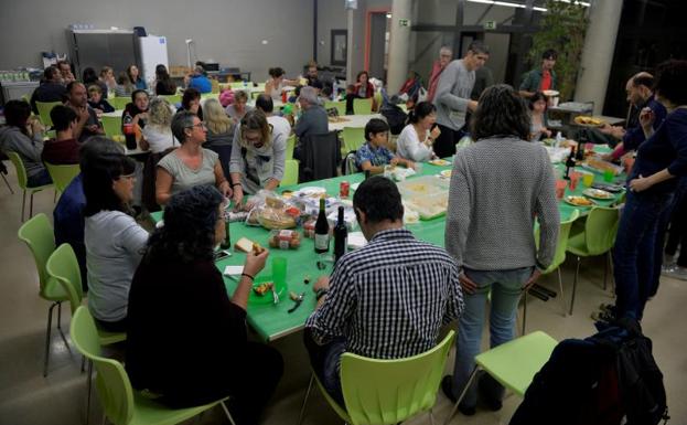 Varias personas cenan en un colegio ocupado de Vic (Barcelona)./Vincent West (Reuters)