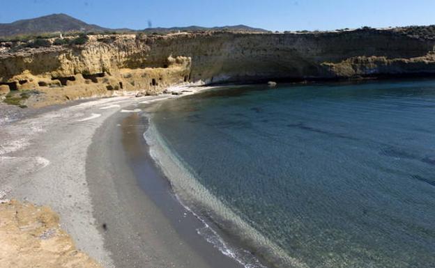 La playa de Cala Blanca, una media luna perfecta abierta al mar. Al fondo, el Lomo de Bas./