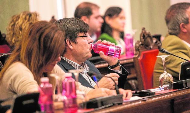 El concejal socialista Francisco Aznar, bebiendo agua ayer durante el Pleno. Al fondo, la edil de MC Isabel García./J. M. Rodríguez / AGM