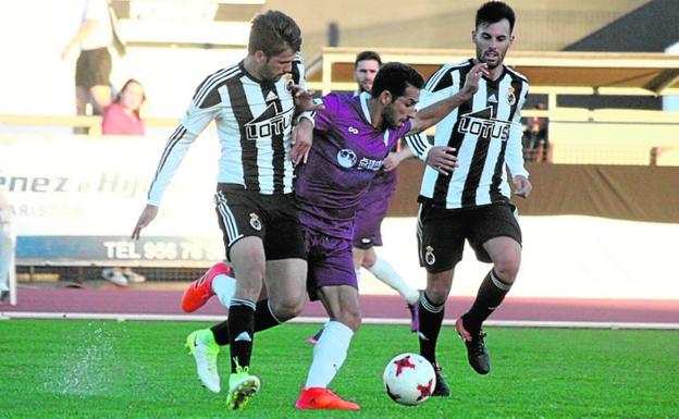 Chupe controla el balón acosado por dos rivales./LOF