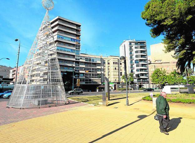 Un hombre pasa junto al árbol, en la Plaza de España./A. Gil / AGM