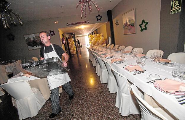 Un empleado de La Dama de Oro, ayer, con una bandeja, ultimando los preparativos en el salón./J. M. R. / AGM