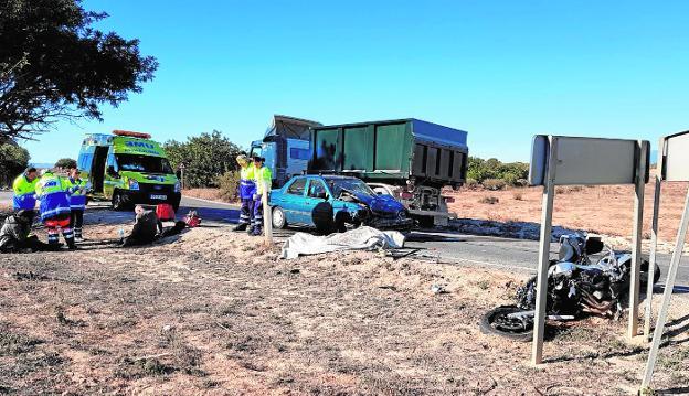 Los servicios de emergencias atienden a los heridos junto al cadáver del motorista, tapado con una manta, y los vehículos implicados./LV