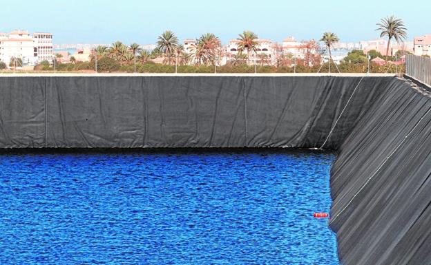 Balsa de contención de aguas construida en Mar de Cristal, en la ribera sur del Mar Menor, con una urbanización de viviendas y la laguna al fondo./Pablo Sánchez / AGM