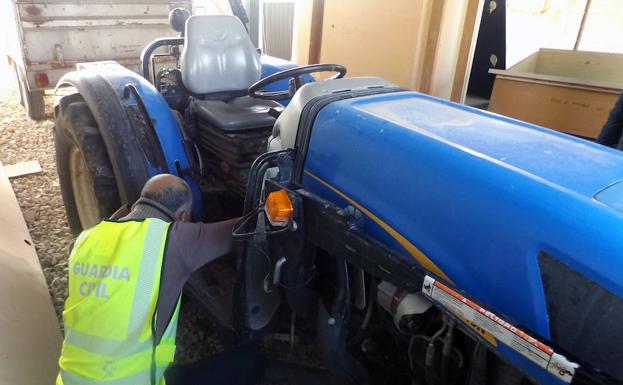Un agente de la Guardia Civil inspecciona el tractor robado en Cieza./Guardia Civil