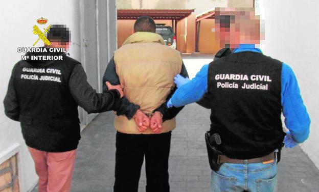 Dos agentes de la Benemérita trasladan al supuesto atracador tras su detención./G. Civil