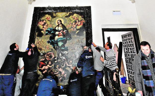 Colocación de un cuadro en el Palacio de Guevara de Lorca, un inmueble dañado por el terremoto./Paco Alonso