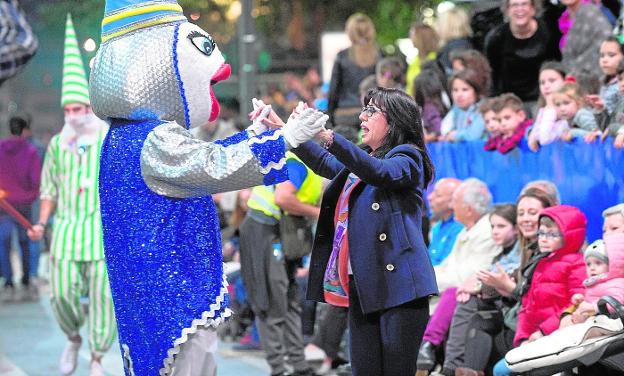 La mascota del Entierro, anoche, baila de alegría con una espectadora por la Gran Vía, ante la mirada atónita de los más pequeños./Javier Carrión / AGM