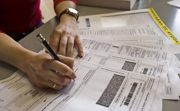 Una mujer cumplimentando la declaración de la renta./LV