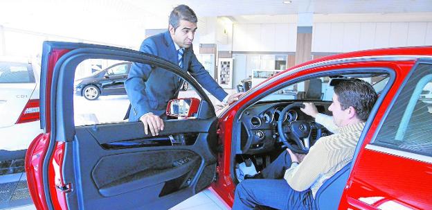 Un empresario examina un vehículo en un establecimiento de 'renting'. / jesús andrade