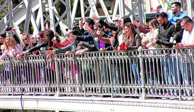 Un grupo de gitanos lanza claveles al río, a su paso por Murcia, en los actos de ayer. AGM/JUAN C. CAVAL /