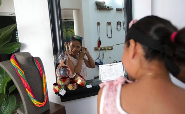 Una cliente se prueba pendientes en la tienda de 'Chureca Chic'. /INTI OCON (AFP)