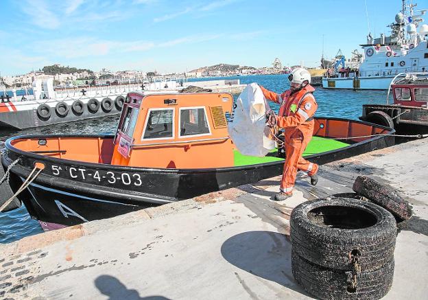 Un trabajador de Cemesa, con una bolsa de plástico, en el muelle de La Curra./J.M.Rodríguez/ AGM