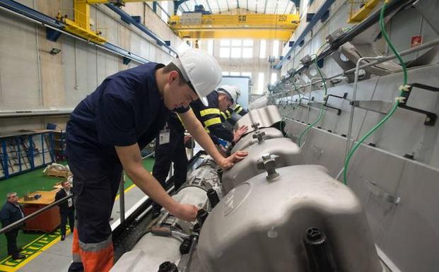 Tres alumnos trabajan en un motor para un barco australiano/A. G.