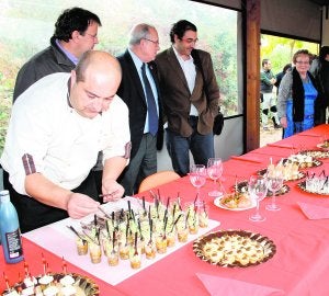 Domingo Valero prepara los vasitos de hongos escabechados. Detrás, Domingo Aranda (c) y Fernando Galán (d). ::
M. A. R./