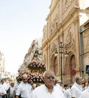 La Patrona pasa ante la iglesia de El Carmen en su camino hacia la capilla de las Siervas. :: SONIA M. LARIO / AGM/
