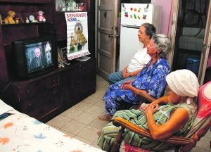 Tres mujeres católicas observan en la televisión la intervención del viernes del arzobispo de Santiago de Cuba, Dionisio García Ibáñez. ::
EFE/