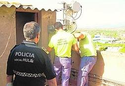 Los operarios desmantelan las antenas ante un policía local. Foto: J. L. P./