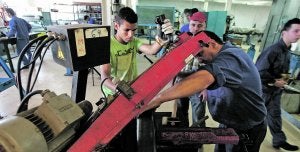 Un grupo de alumnos del Instituto de Educación Secundaria Politécnico, junto a sus profesores, trabaja en una máquina, en una clase práctica del grado de Soldadura, en una fotografía de archivo. :: J. M. RODRÍGUEZ / AGM/