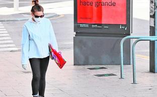 Una joven camina por las calles de Murcia, con una mascarilla, durante el estado de alarma./J. C. CAVAL / EFE