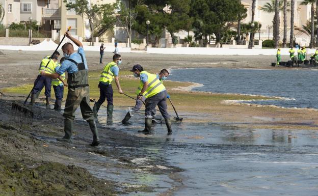 Operarios limpian la playa de Los Urrutias, este miércoles./Antonio Gil / AGM