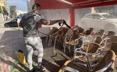 Un hostelero limpia las sillas de su terraza en Cieza./LV