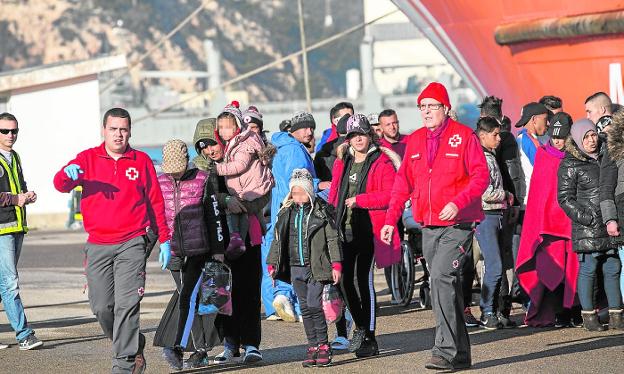 Red Cross volunteers attend to immigrants who arrived in a boat at the Curra dock. 