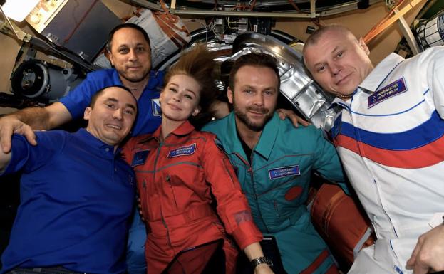 Yulia Peresild, in red, and Klim Shipenko, in green, prepare to return to Earth.