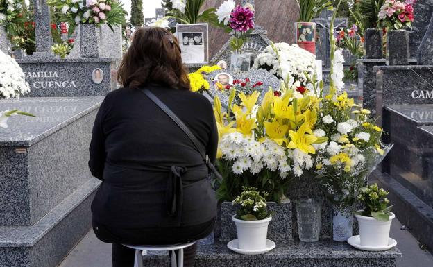 A woman visits the grave of a deceased relative.