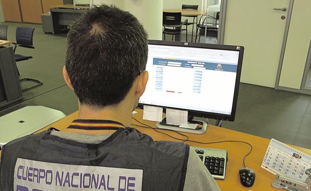 An agent of the National Police tracks information on a computer.