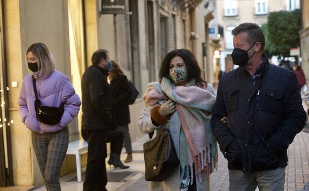 Several people walk through Murcia on a cold day, in a file image.