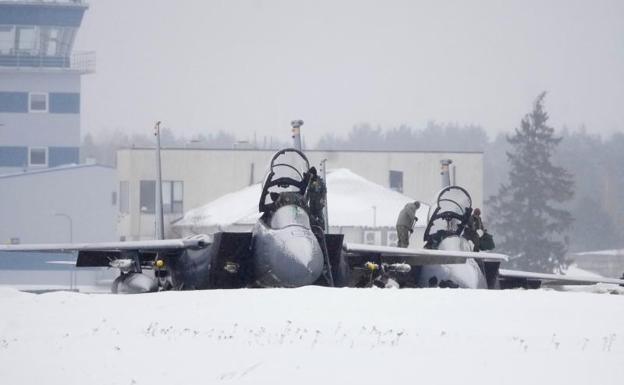 A technician sweeps snow from the wings of a US fighter deployed to Estonia as part of NATO forces.