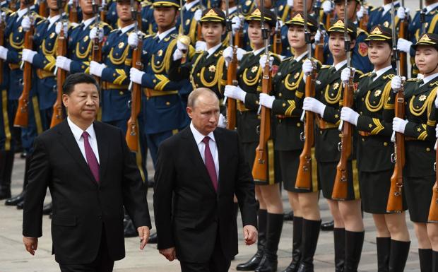 Putin, accompanied by Xi, reviews troops upon arrival in Beijing on a 2018 trip. 