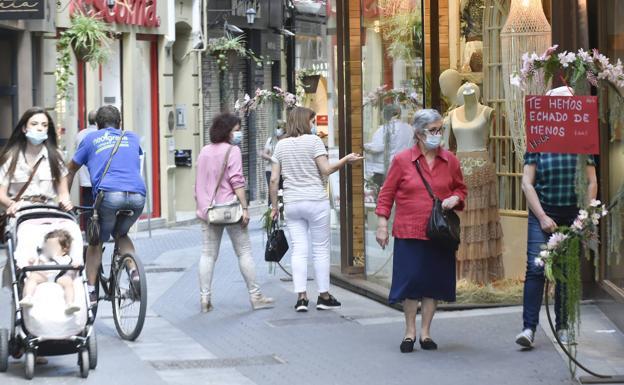 People walk next to several shops located in Murcia, in a file image. 