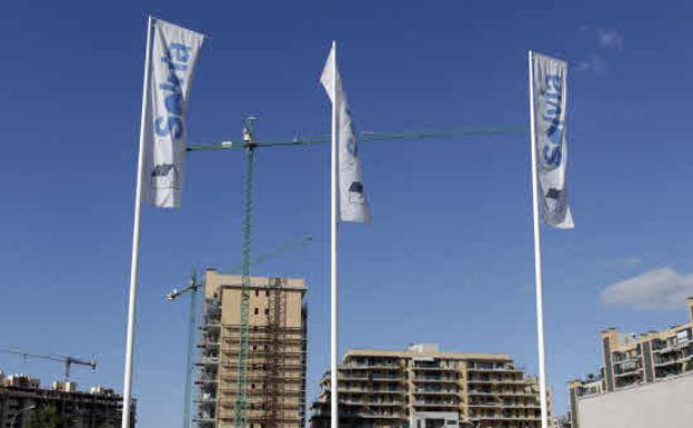 Flags with the name of Solvia next to buildings under construction. 