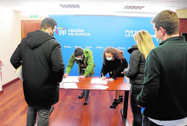 Young affiliates sign the letter to endorse Núñez Feijóo, yesterday afternoon at the regional headquarters. 