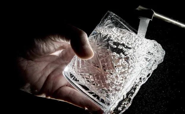 A glass that is filled with water from a tap.
