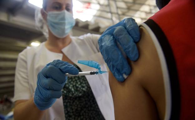 A health worker vaccinates a person in Murcia.