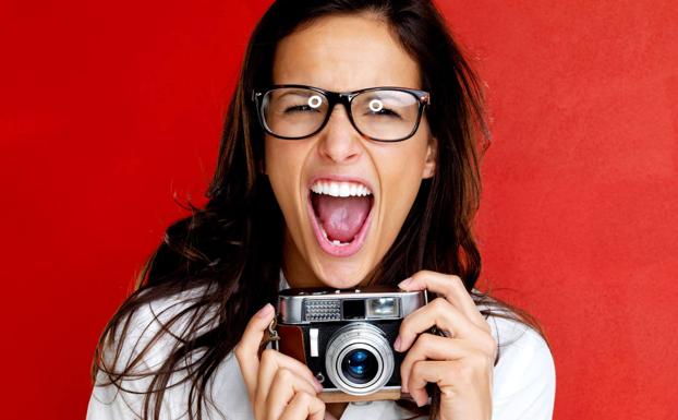 A woman holds a camera, in a file image.